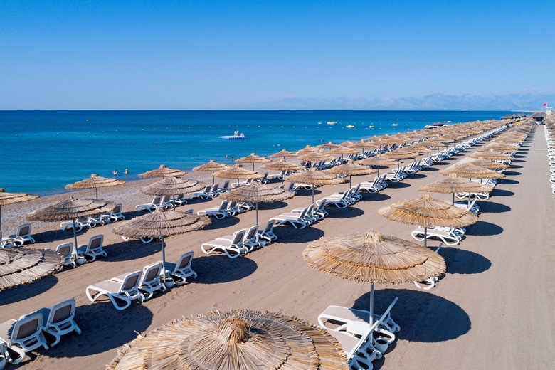 Bãi biển cát Lara tại Antalya với hàng dừa và ghế nằm ven biển