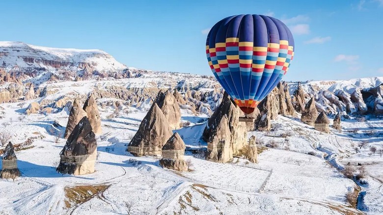 Khinh khí cầu bay trên thung lũng Cappadocia phủ tuyết mỏng vào mùa đông