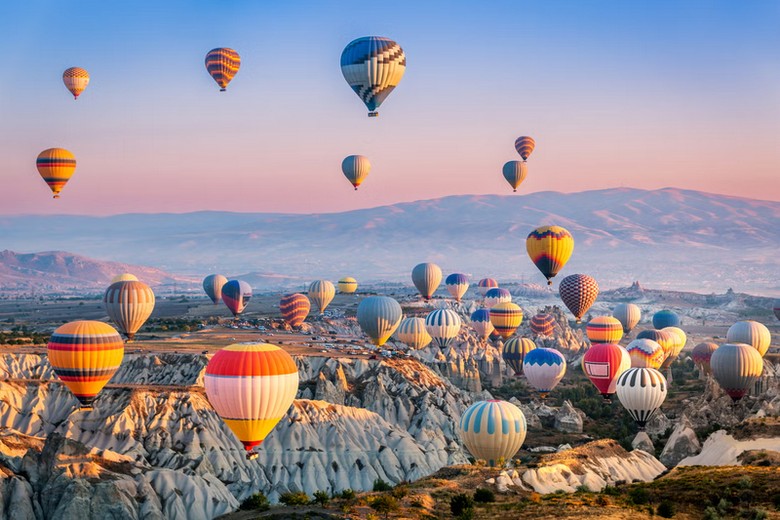 Khinh khí cầu nhiều màu lấp đầy bầu trời Cappadocia lúc rạng đông