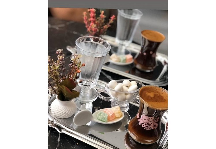 Ly rakı màu trắng đục bên cạnh ly nước lọc và đĩa phô mai trắng